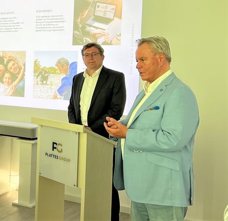 Redner Holger Schlechter (CFO IFZA Dubai) mit Willi Plattes am Stehpult.