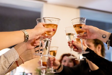 Gläser werden festlich zum Anstoßen erhoben.