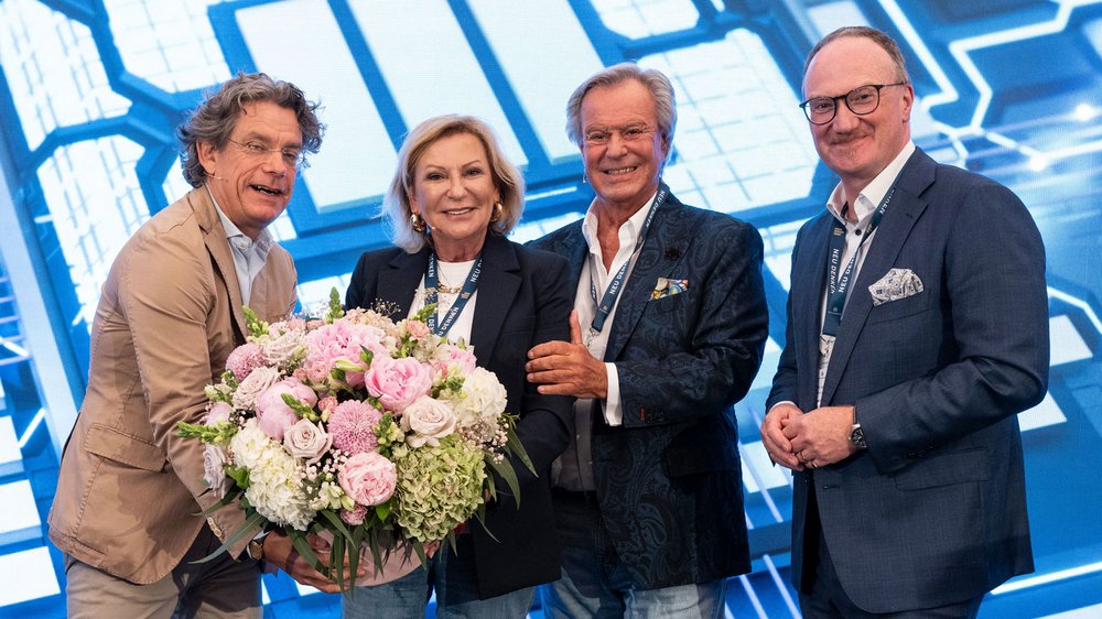 Frank Sieren, Sabine Christiansen, Willi Plattes und Prof. Dr. Lars Feld werden nach dem letzten Vortrag mit einem Blumenstrauß geehrt und nehmen diesen in Empfang