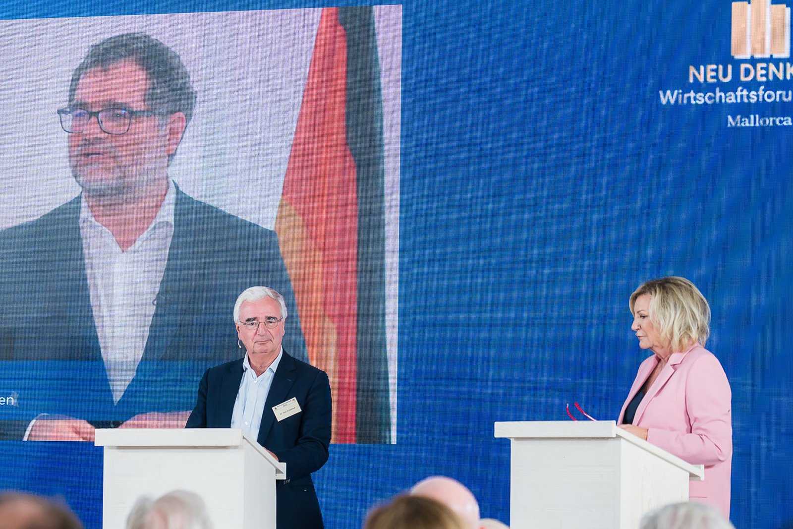 Dr. Paul Achleitner (Deutsche Bank) und Sabine Christiansen beim Wirtschaftsforum Neu Denken im Juni 2021 auf Mallorca. Auf der Leinwand Staatssekretär Wolfgang Schmidt.