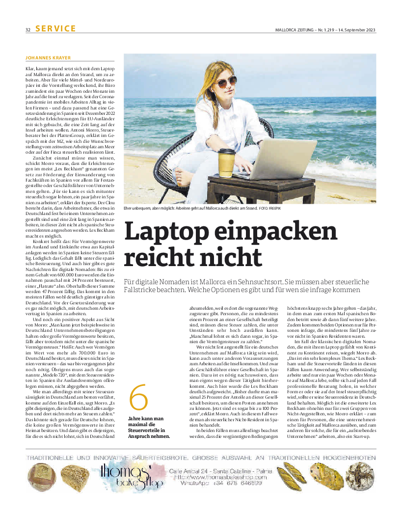 Zeitungsartikel mit Foto von einer Frau am Laptop am Strand