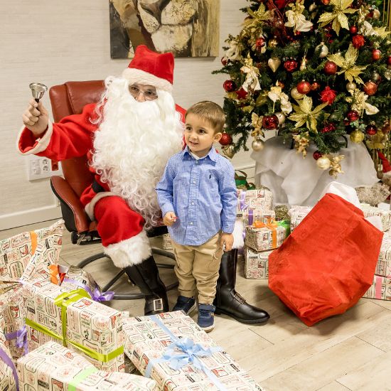 Bild von Kind mit Weihnachtsmann und Geschenken